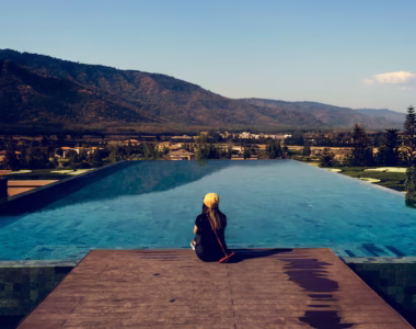 woman-sitting-by-poolside-wiht-mountain-view_53876-14438
